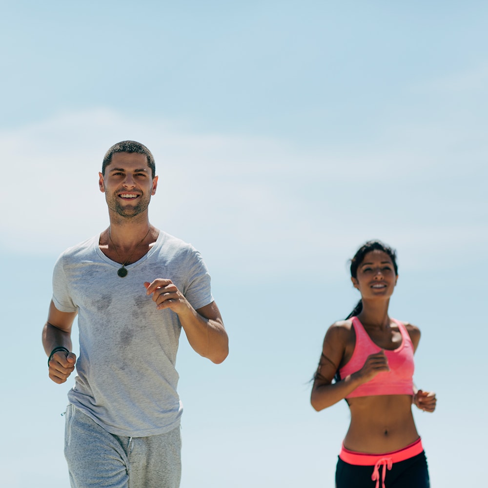 Man and woman running outdoors at the track at suffolk downs
